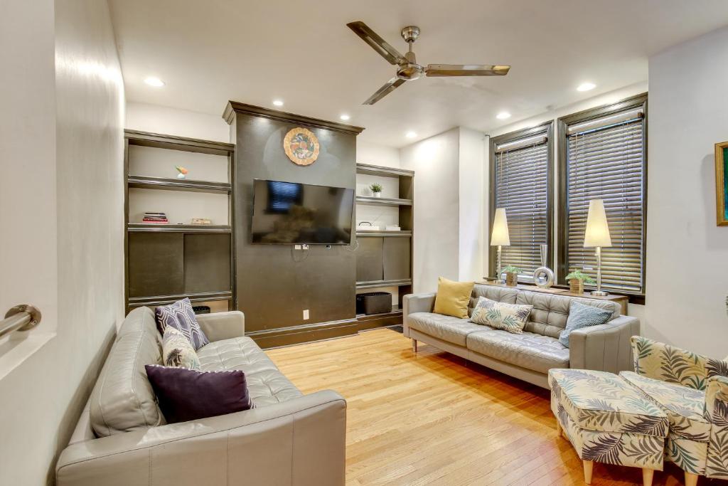 a living room with two couches and a flat screen tv at Walk to Tower Grove Park St Louis Getaway in Tower Grove