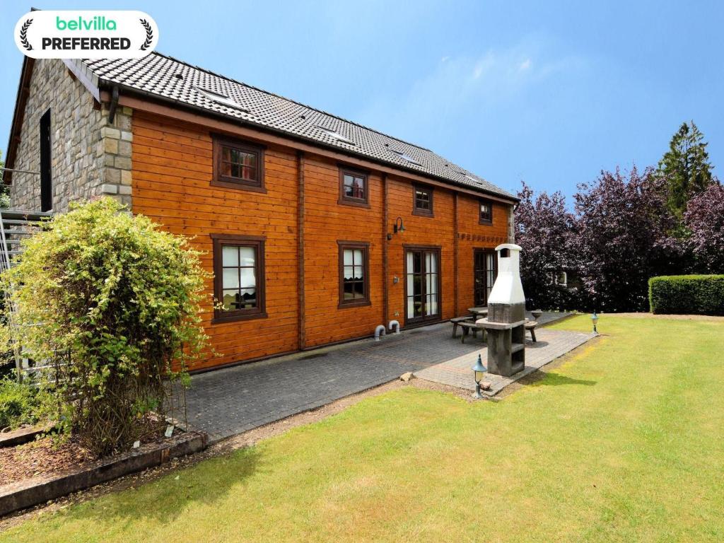 a large brick building with a bench in front of it at Elegant Villa with Sauna in Durbuy