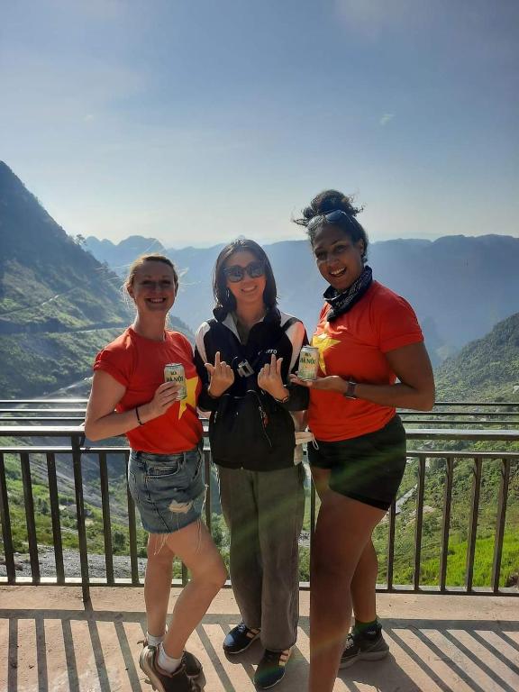 three women posing for a picture in front of a mountain at Napoli Hostel Cat Ba in Cat Ba