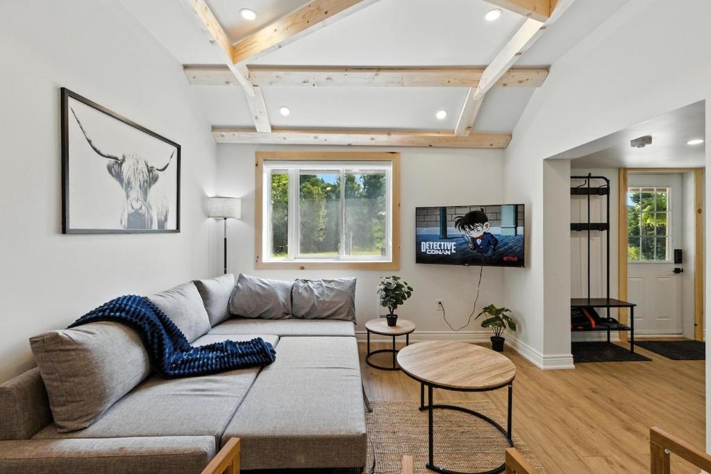 ein Wohnzimmer mit Sofa und Fernseher in der Unterkunft Cozy Cottage Retreat Private 2 Acres, Near Lake in Harcourt