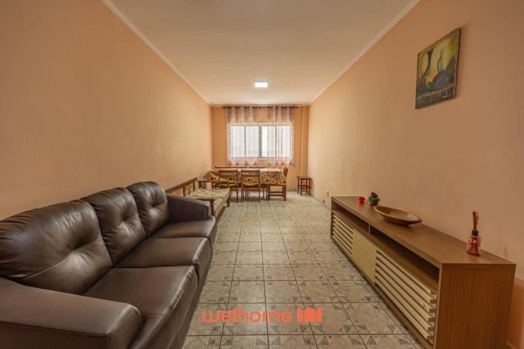 uma sala de estar com um sofá e uma mesa em Apartamento em Praia Grande a 600 metros do mar na Praia Grande