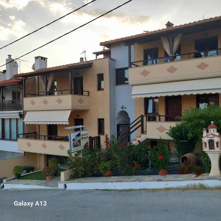an apartment building with flowers in front of it at Pansion Fani in Ouranoupoli