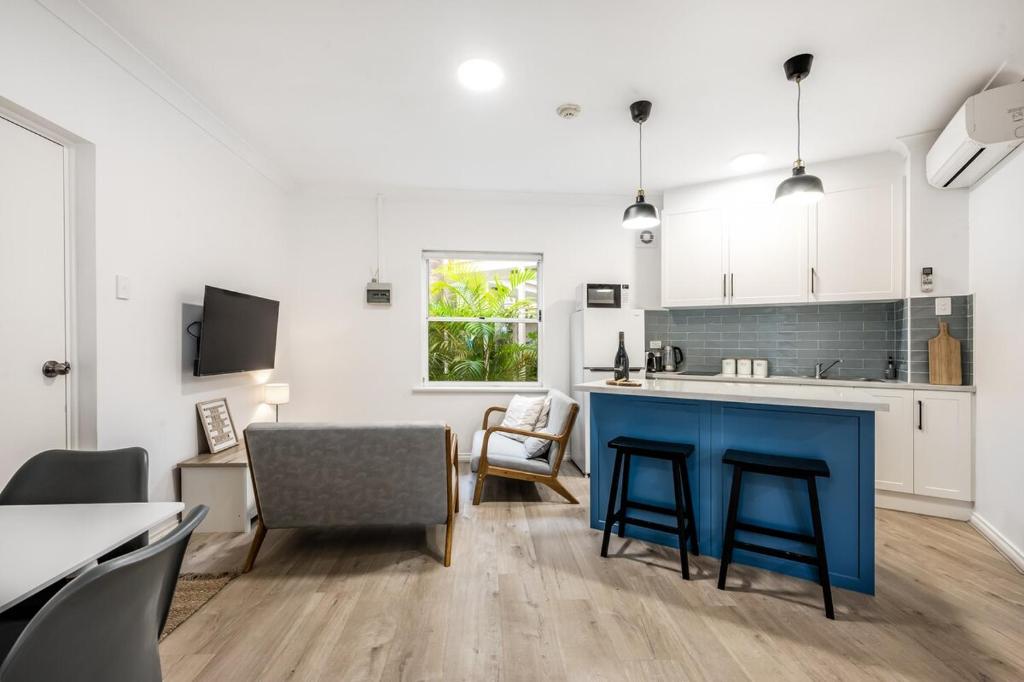 una cucina e un soggiorno con un'isola blu in una stanza di Seaside Victor Harbour Apartment a Victor Harbor