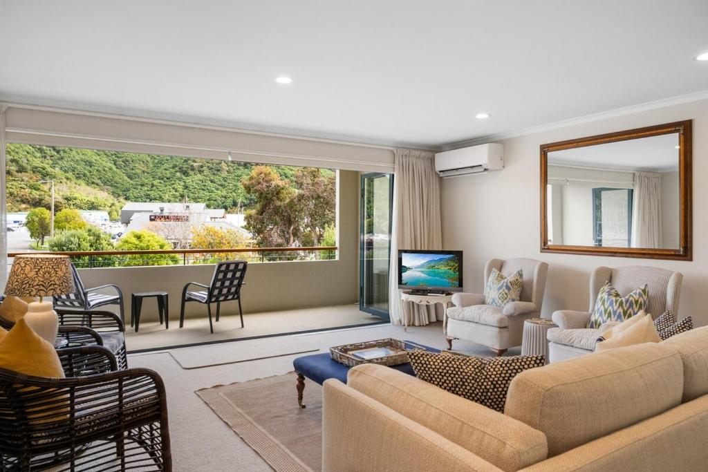 a living room with a couch and a television at Marina Edge Marlborough Sounds Apartment in Waikawa