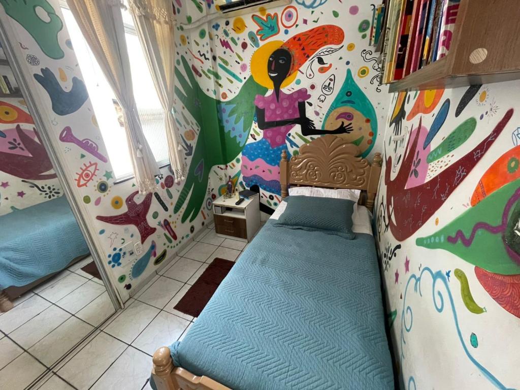 a small room with a bed with a painting on the wall at CASA de TEMPORADA para COP 30 in Belém