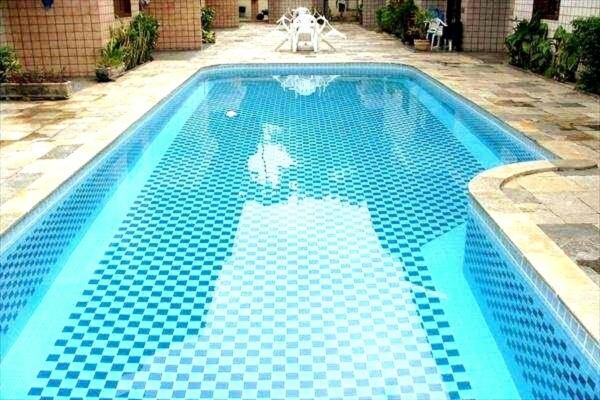 a blue swimming pool with blue tiles on it at FLAT EM JUQUEHY COM AR COND, PISCINA e CHURRASQUEIRA in São Sebastião
