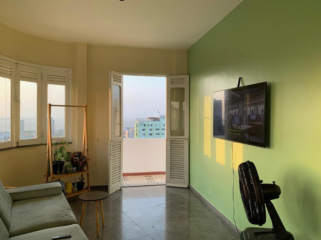 a living room with a couch and a flat screen tv at Quarto suíte para COP30 in Belém