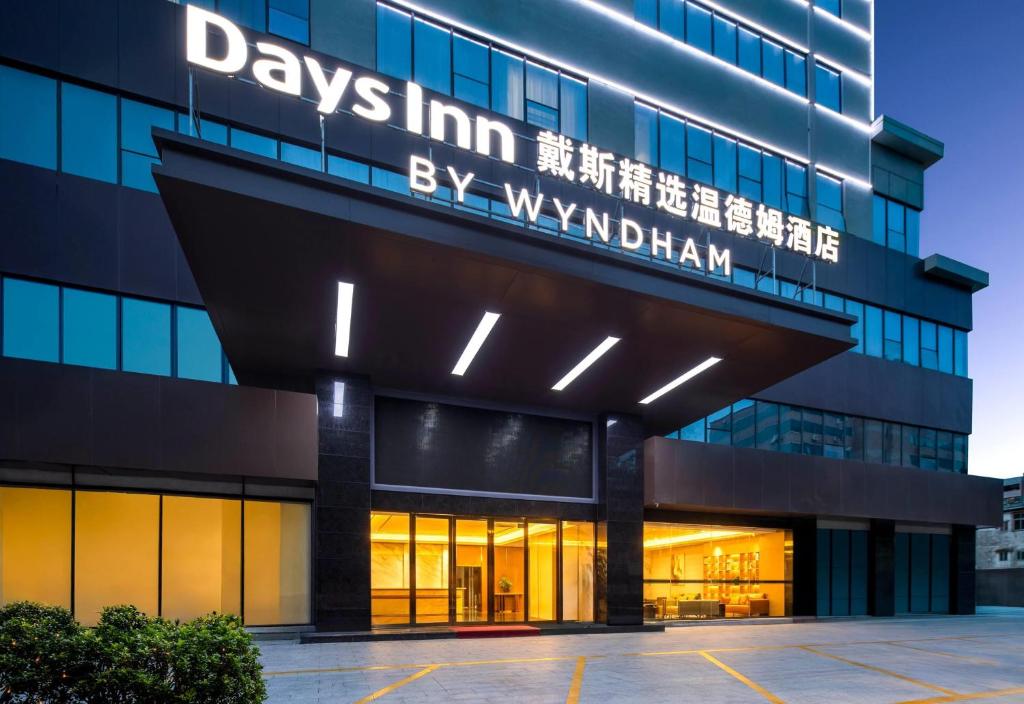 an office building with a sign that reads days inn inn suites by warrantedan at Days Inn by Wyndham Zhuhai Qinglv Road in Zhuhai
