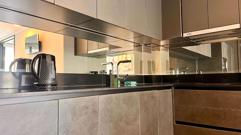 uma grande cozinha com armários de aço inoxidável e electrodomésticos de aço inoxidável em Exclusive Fully Equipped Apartment in Las Condes em Santiago