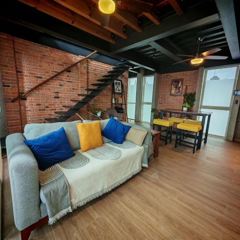 a living room with a couch and a brick wall at Brick Box Loft con Balcon in Hércules