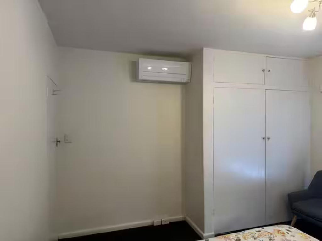 a room with a bed and a white cabinet at Spacious Room in Ivanhoe, Melbourne in Melbourne