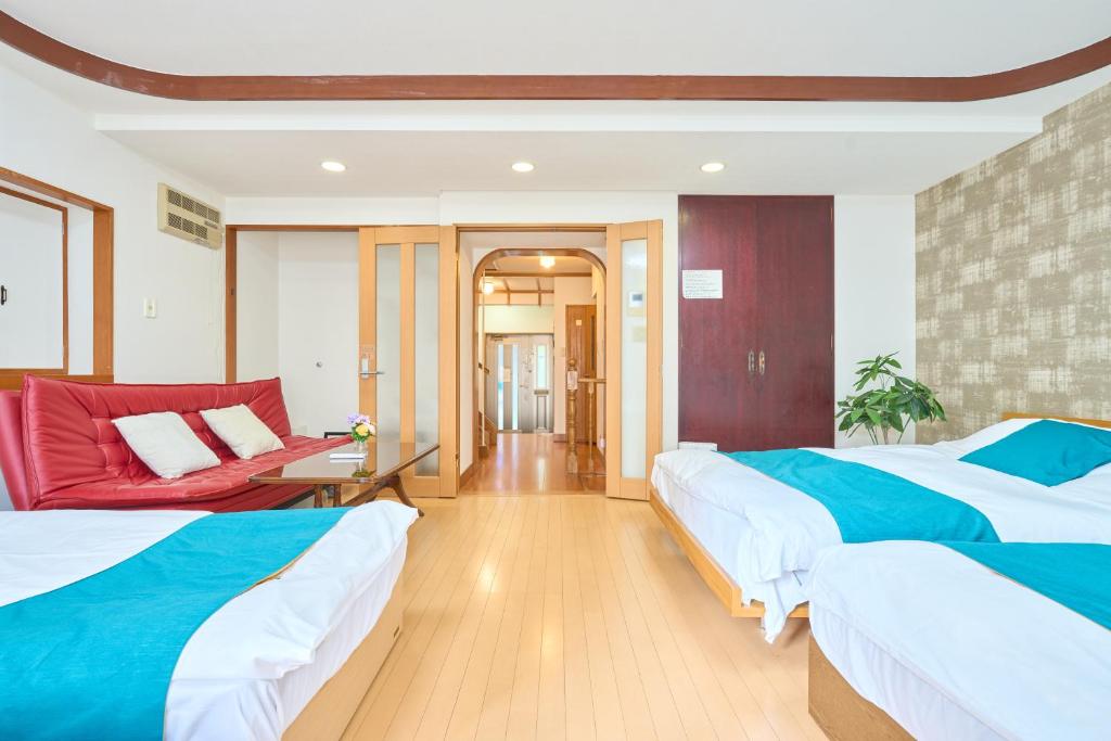 une chambre d'hôtel avec deux lits et un canapé dans l'établissement A-Shinjuku BigRoof Balcony, 6BedRoom,140sqm House for 20ppl,4min to Yotsuya-Sanchome Sta, à Tokyo