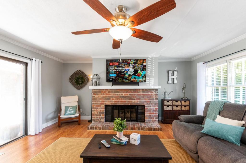 een woonkamer met een plafondventilator en een open haard bij 3926 Pineview Smyrna in Vinings