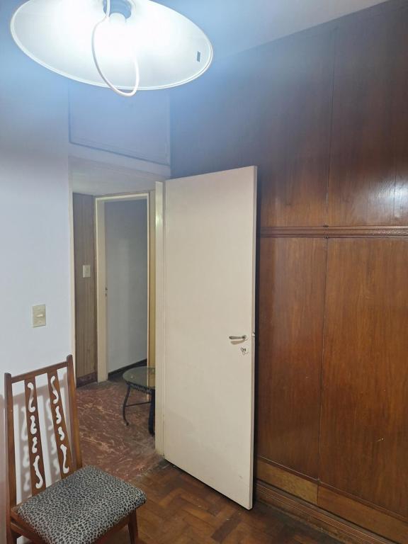 a room with a door and a chair and a lamp at Espectacular Departamento in Rosario