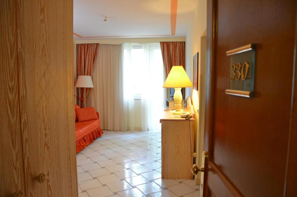 プンタ・アーラにあるGolf Hotel Punta Ala Apartmentsのベッドと窓のあるホテルの部屋