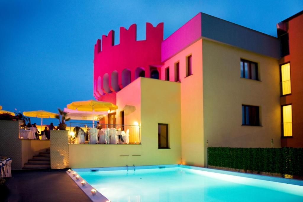 Villa con piscina frente a un edificio en Hotel il Castelletto, en Casarile