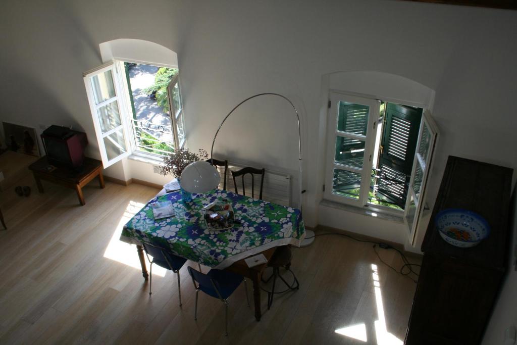 ein Esszimmer mit einem Tisch und 2 Fenstern in der Unterkunft La Casa Rossa in Lerici