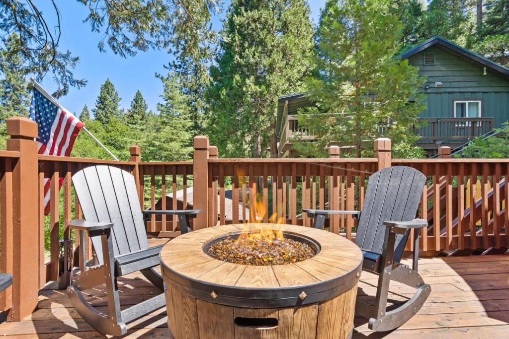 two chairs and a fire pit on a deck at Lewis Creek cabin near Yosemite king beds in Oakhurst