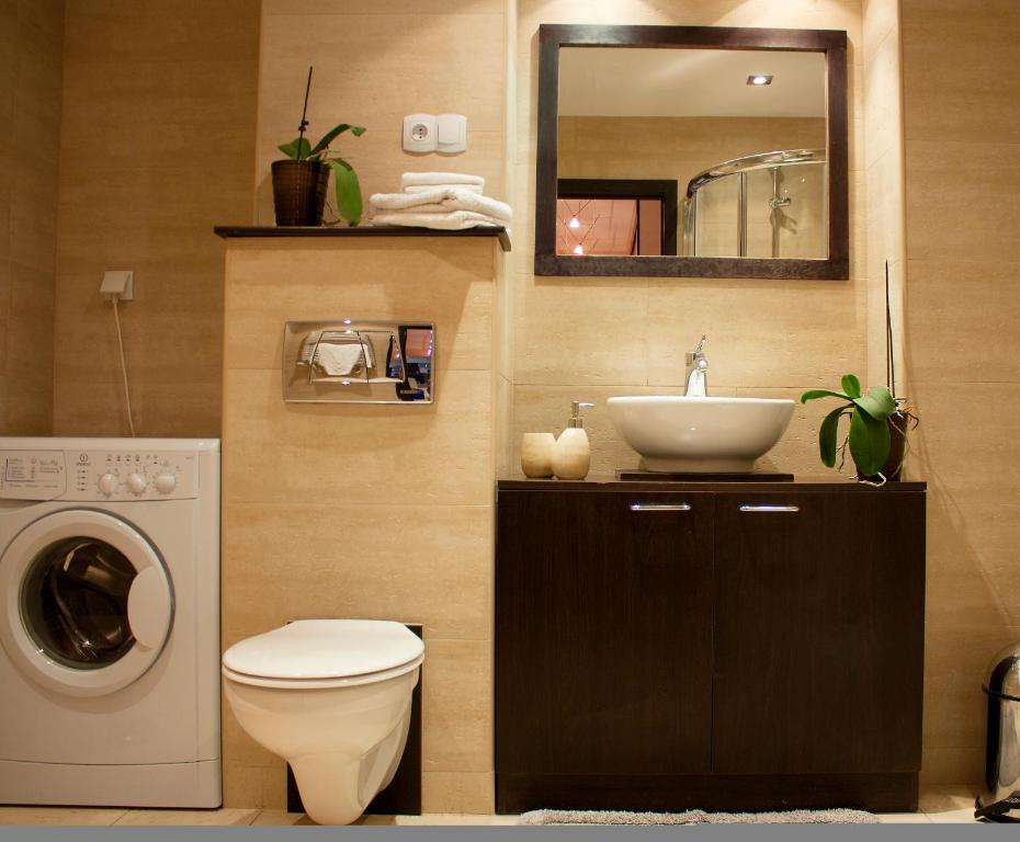 a bathroom with a sink and a washing machine at TK Apartments Spiżowa in Wrocław