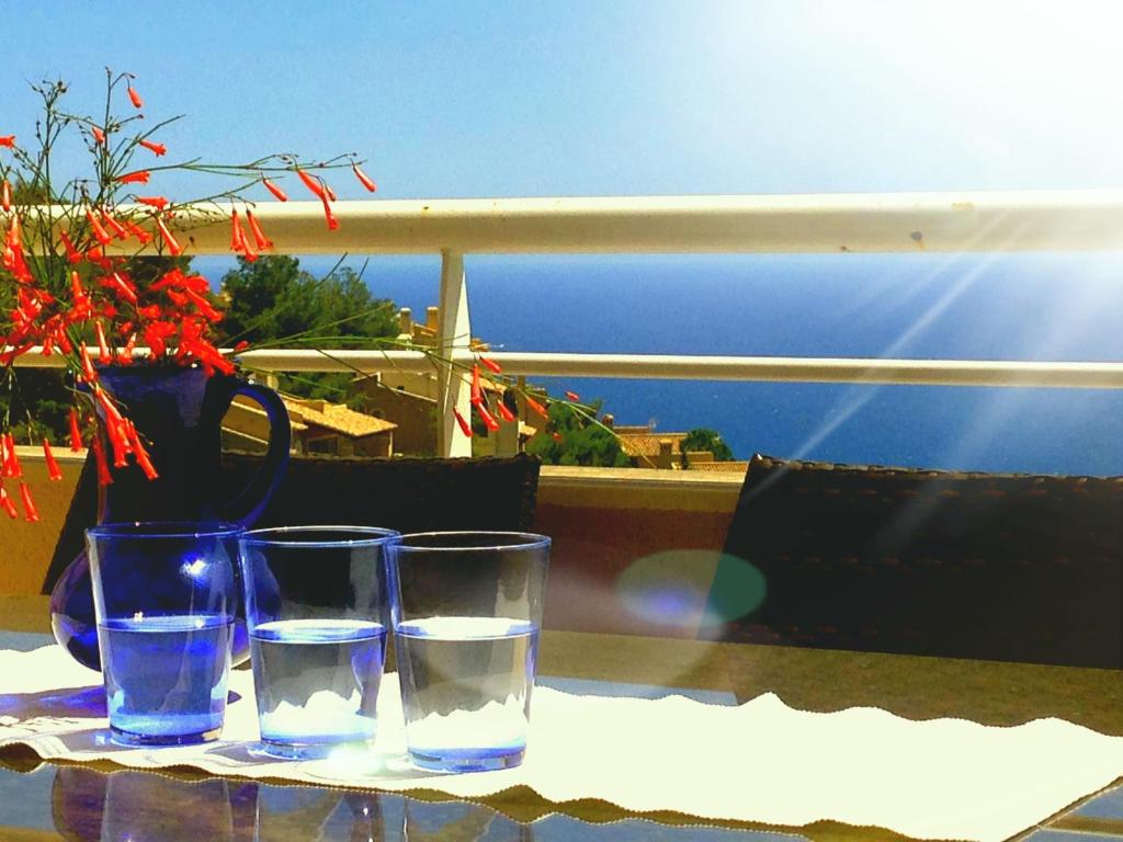 una mesa con dos vasos y un jarrón con agua en Balcon de Altea hills, en Altea