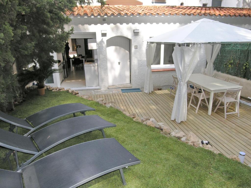 ロダ・デ・バラにあるCasa en el Roc de Sant Gaietaのデッキ(椅子、テーブル、白い傘付)