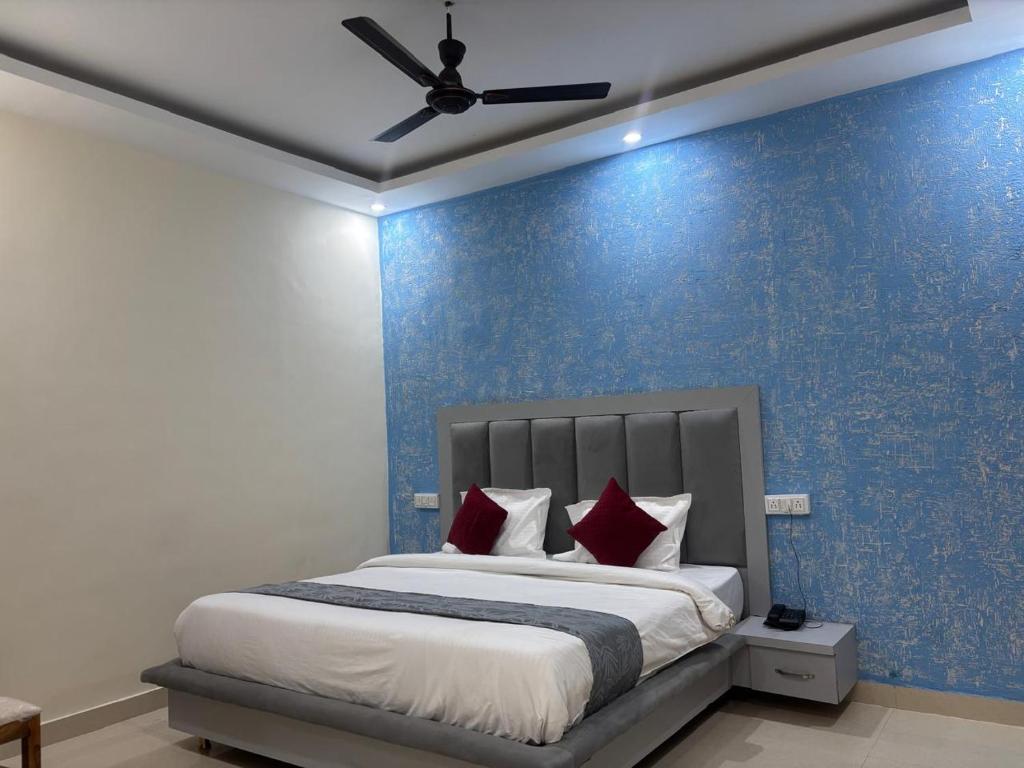 a bedroom with a bed with a blue wall at Hotel Tirth Heritage Step Away from Ram Mandir in Jāmb