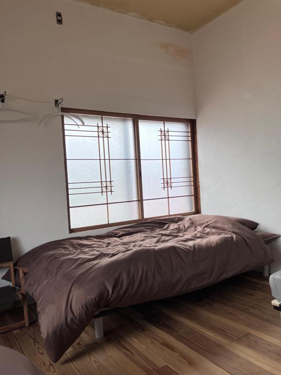 Ένα ή περισσότερα κρεβάτια σε δωμάτιο στο MOTORYOKAN Guesthouse & Cafe