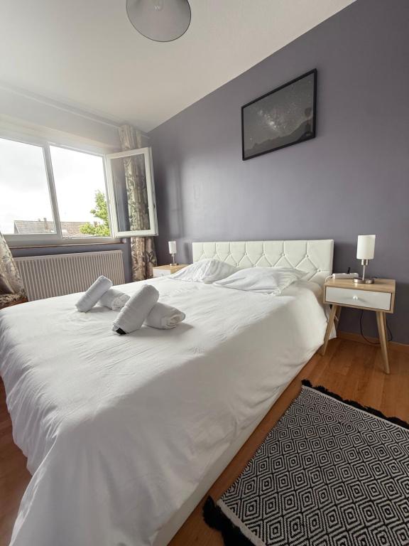 a large white bed with two pillows on it at Tout le monde sous le meme toit - 10 voyageurs - 25 mn europapark in Benfeld