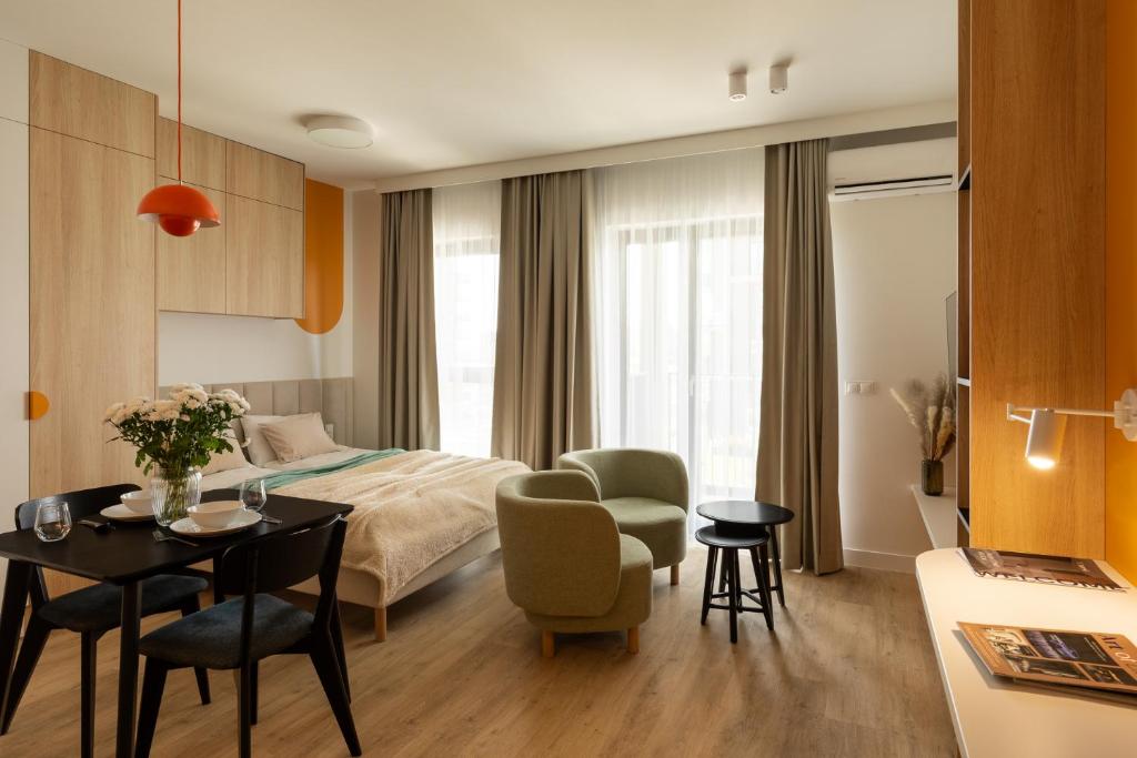 a hotel room with a bed and a table and chairs at Trevi Apartments Katowice - City Center - Spodek MCK NOSPR in Katowice