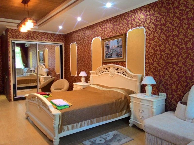 イェウパトーリヤにあるGuest House Otdykhaem Letomのベッドルーム(大型ベッド1台付)、バスルームが備わります。