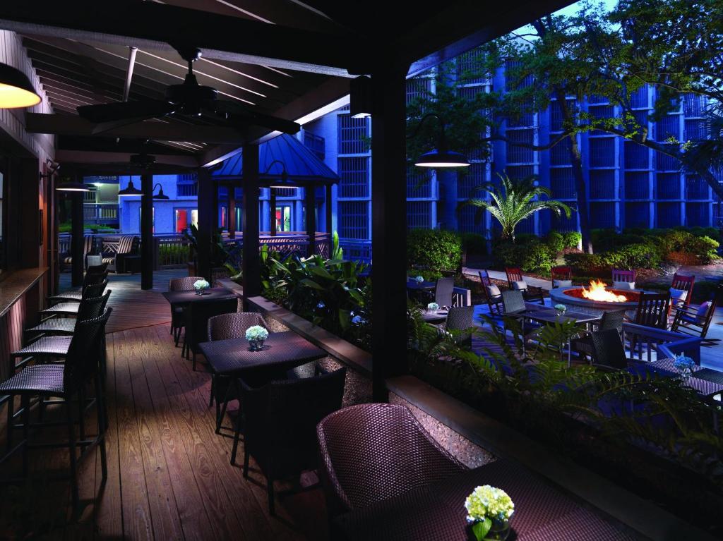 Un restaurante con mesas y sillas por la noche. en Omni Hilton Head Oceanfront Resort, en Hilton Head Island