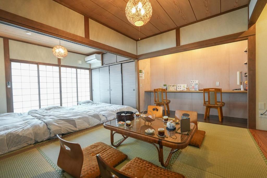une chambre avec un lit, une table et des chaises dans l'établissement 鈴鹿サーキット15分最大9名和室亀山茶4月open, à Kameyama