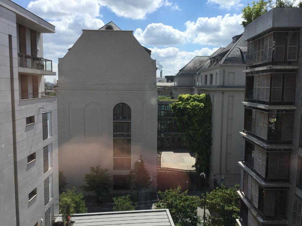un grand bâtiment blanc dans une ville avec des bâtiments dans l'établissement Appartement Lumineux Accor Arena Paris 13, à Paris