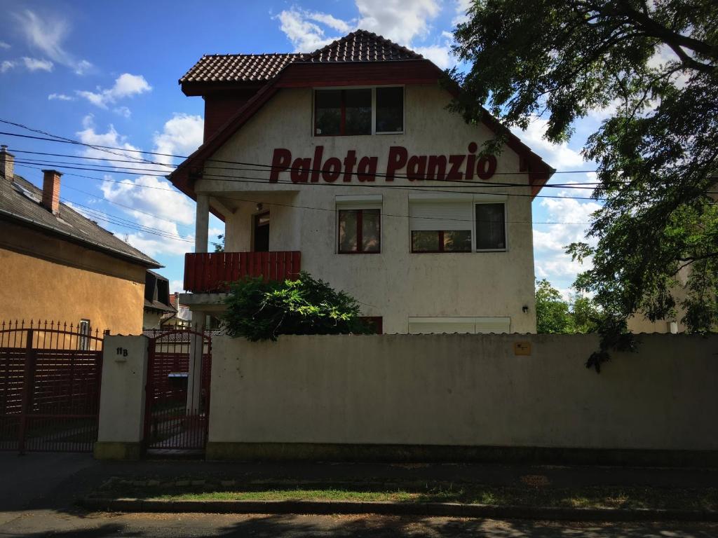 una casa blanca con una señal que dice pula pombota en Palota Panzió, en Budapest