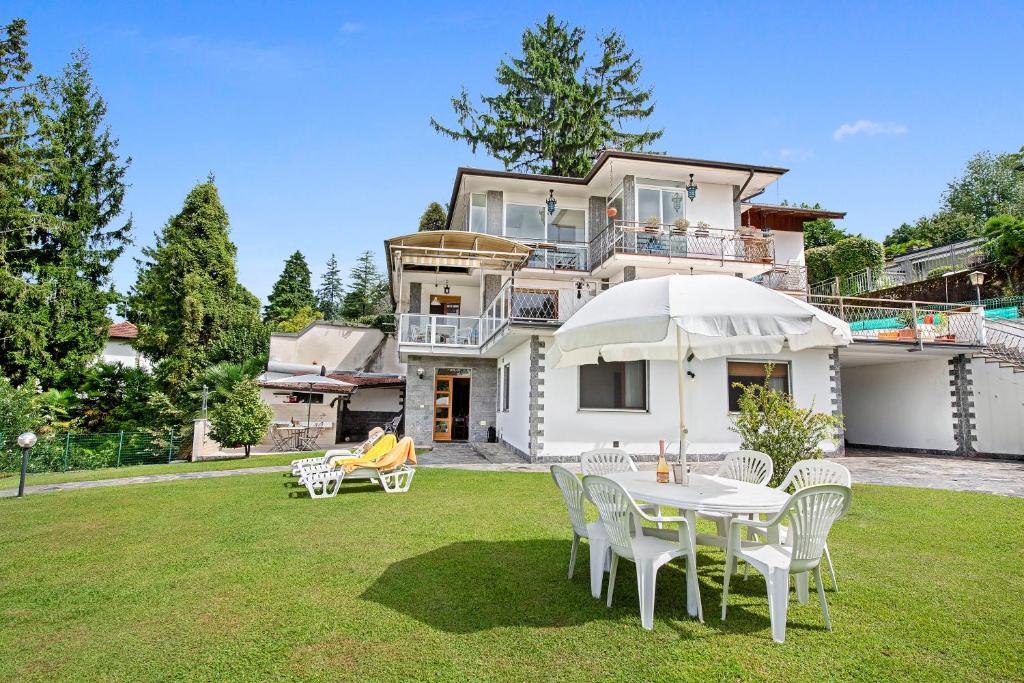 a house with a table and chairs in the yard at Casa Malpensata - Happy Rentals in Porto Valtravaglia