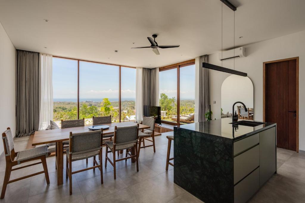 Una cocina y un comedor con mesa y sillas. en Brand new 2-bedroom ocean view villa, en Uluwatu