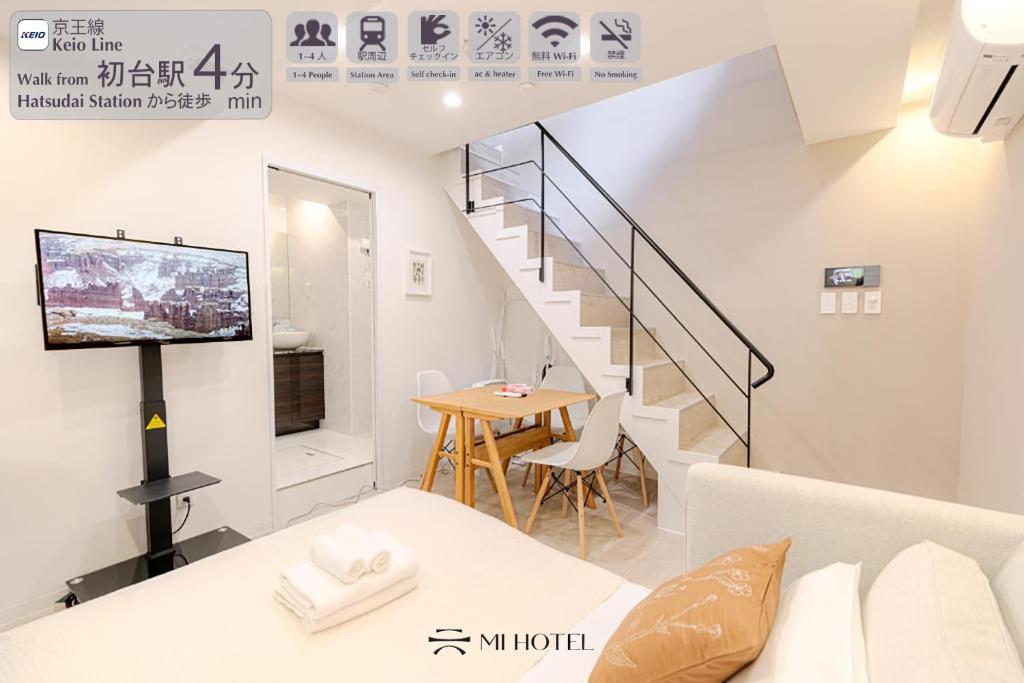 a living room with a staircase and a table at Shinjuku iotele-hatsudai House in Tokyo