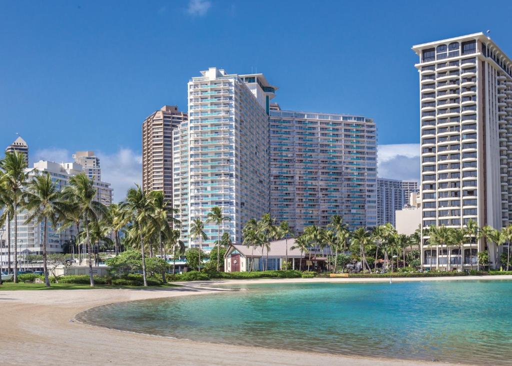 a beach with palm trees and tall buildings at Waikiki Marina Resort at the Ilikai in Honolulu
