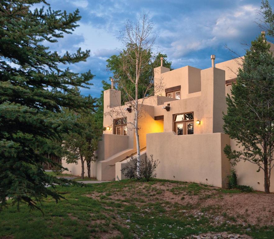 a house on a hill with trees in front of it at WorldMark Taos in Taos