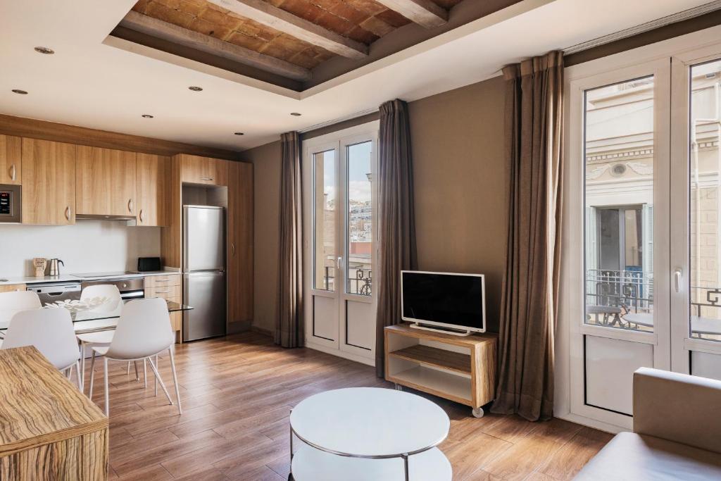 a living room with a television and a kitchen at Barcelona Apartment Milà in Barcelona