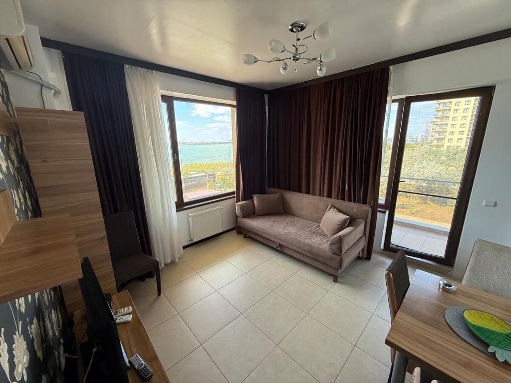 a living room with a couch and some windows at Summerland Flat in Mamaia