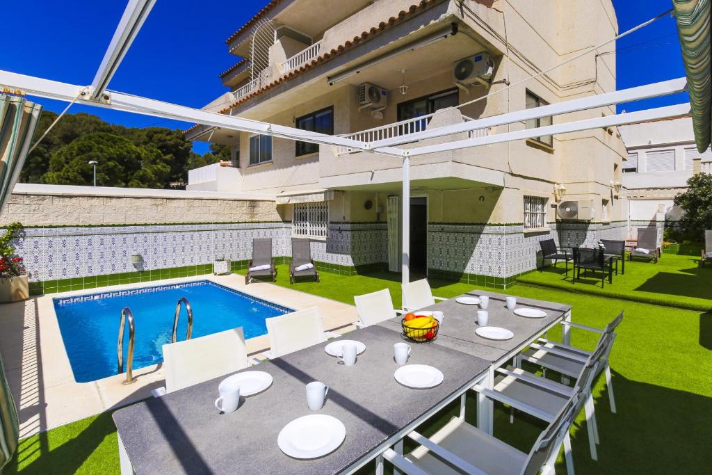 a patio with a table and chairs and a swimming pool at Casa MEDITERRANEA in Salou