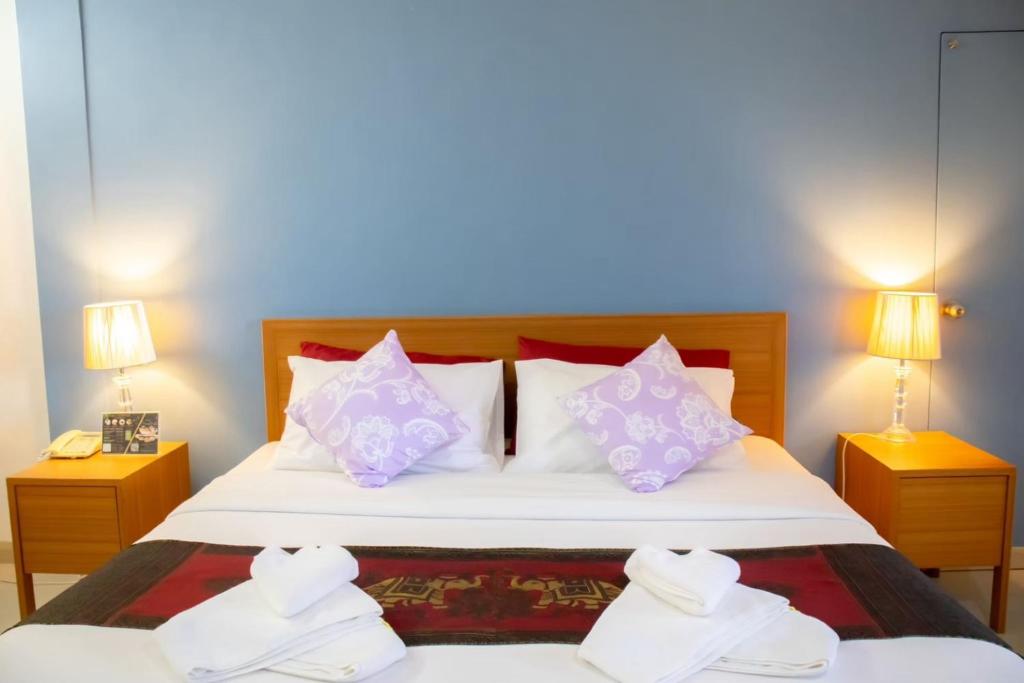 ein Schlafzimmer mit einem großen Bett mit zwei Nachttischen in der Unterkunft C&C Bandu in Ban Den Charoen