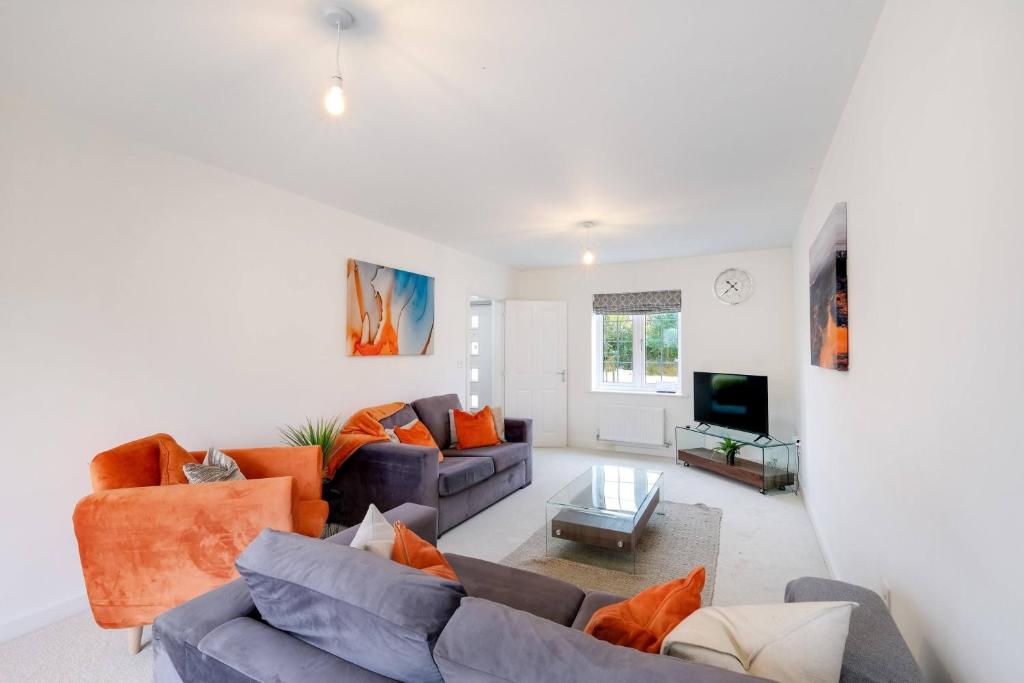 a living room with two couches and a tv at 6 Bedroom 3 Bathroom House in Bicester Village in Bicester