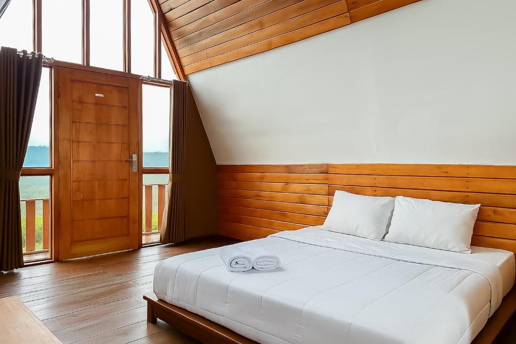 a bedroom with a bed with two glasses on it at S Tilu Heroy Hill Resort Pangalengan Bandung RedPartner in Pengalengan