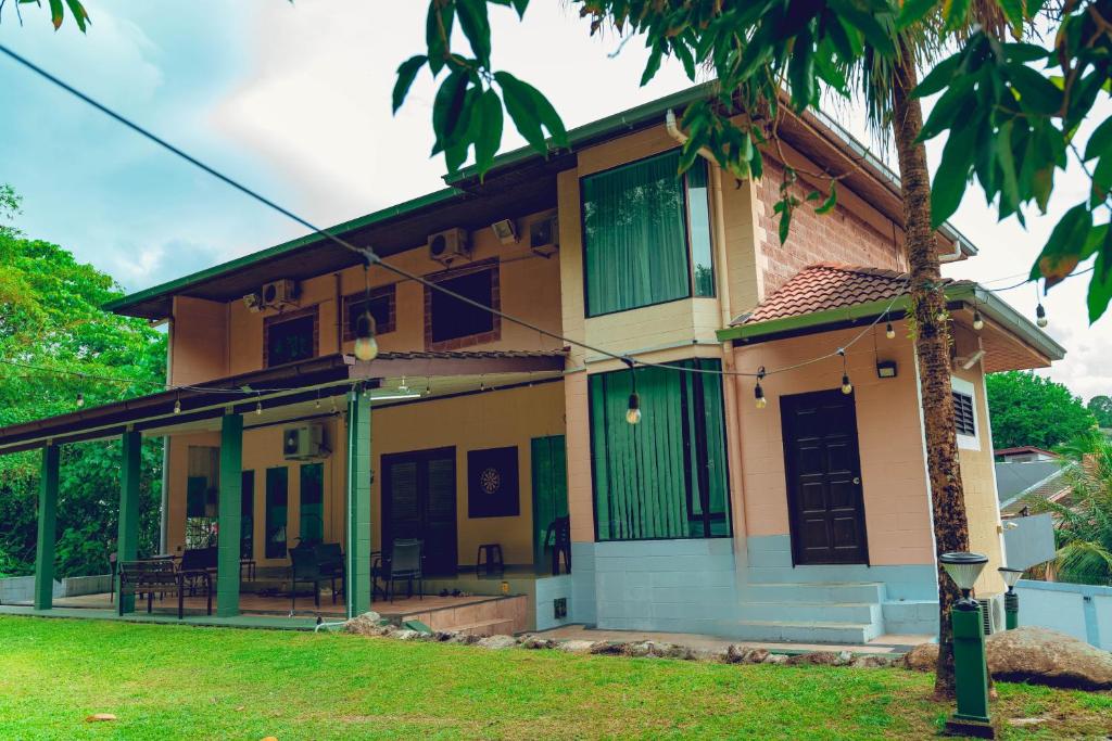 a house with green shutters and a palm tree at Villa Sapphire by Blue Robin - Private Taiping Villa 20pax River & Waterfall in Taiping