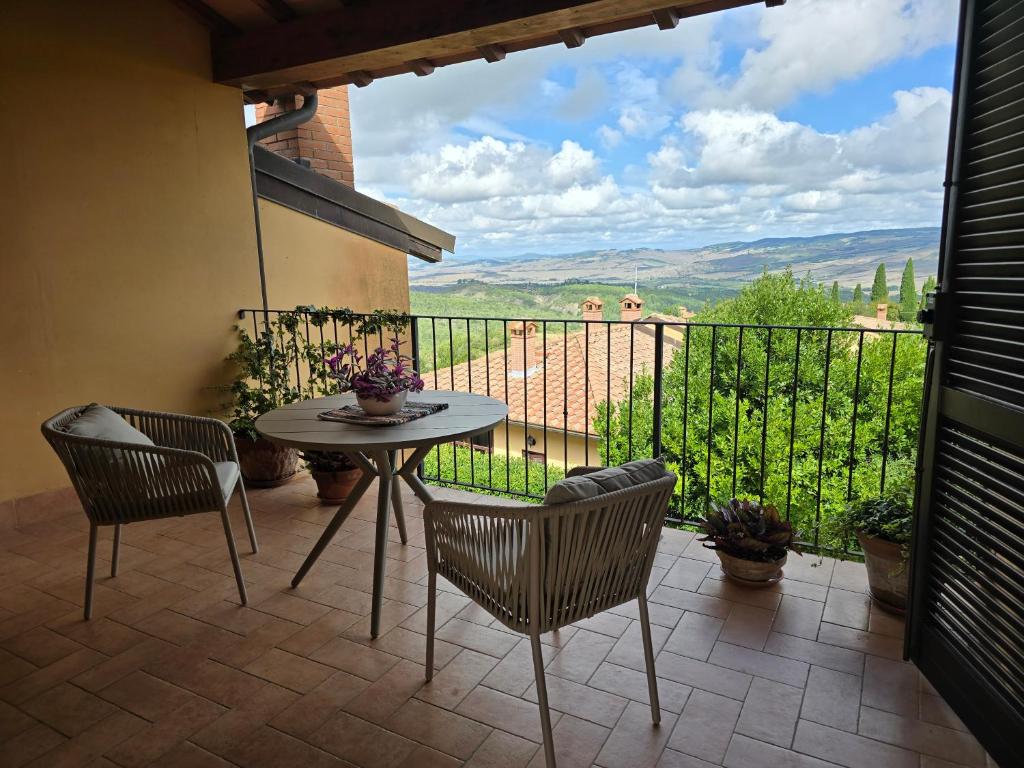 a patio with a table and chairs on a balcony at Finestra Della Val D'Orcia in Contignano