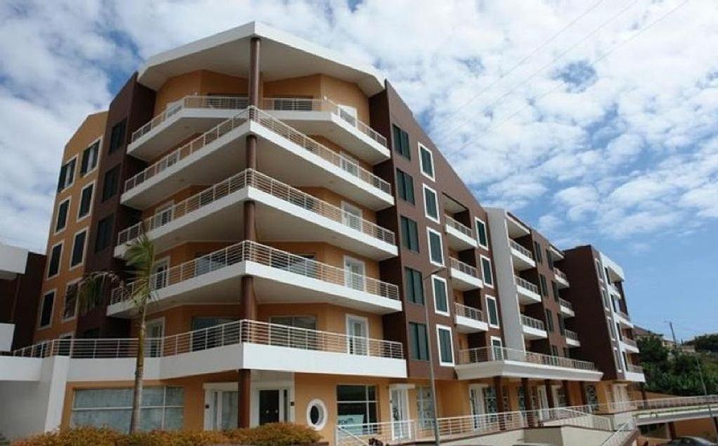 a tall apartment building with balconies on it at Quinta da Torre in Câmara de Lobos