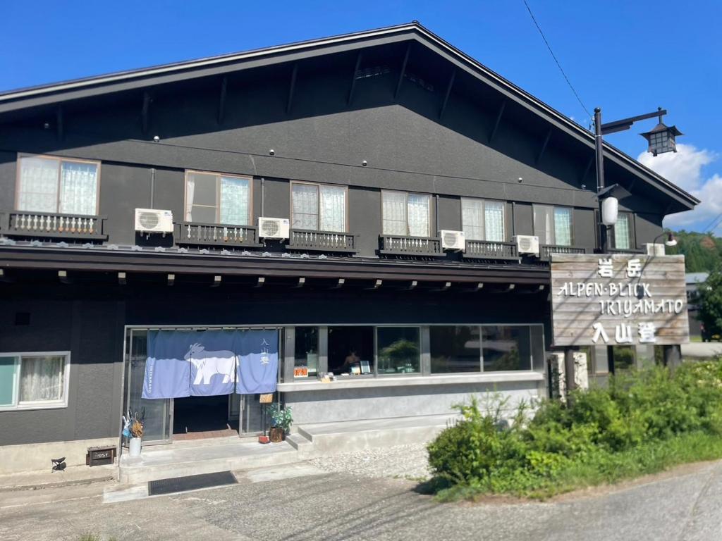 白馬村にある入山登のバルコニーに椅子が置かれた黒い建物