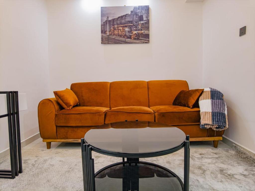 a living room with a brown couch and a table at Modern 1 BR City views Kilimani 12th floor Luxury in Nairobi